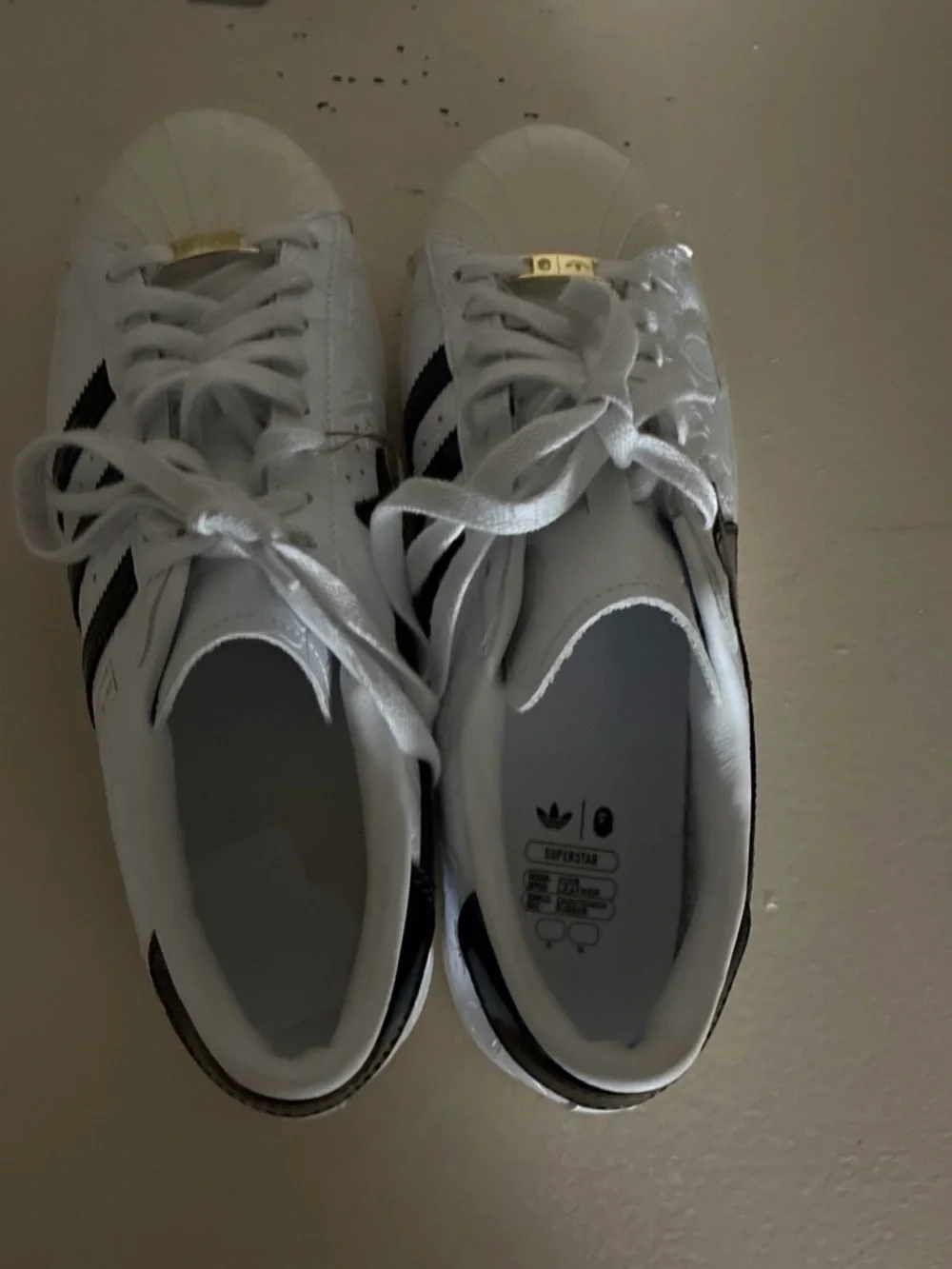 Bape White Sneakers with Black Stripes and Gold Tongue Accents